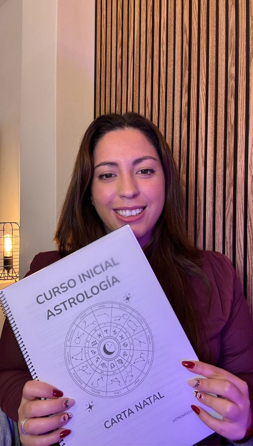 Giuliana sonriendo con el dossier del Curso Inicial de Astrología